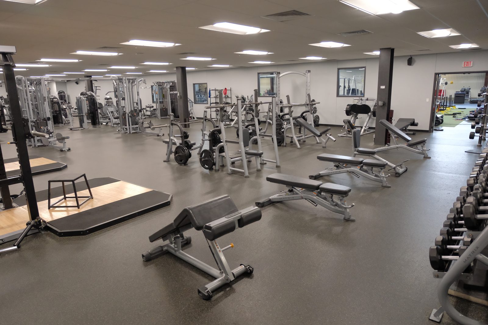 Wide view of the main weight floor with racks, benches and a lifting platform